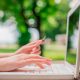 mãos de uma mulher digitando em uma notebook