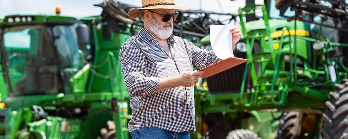 homem em área rural com com caderneta